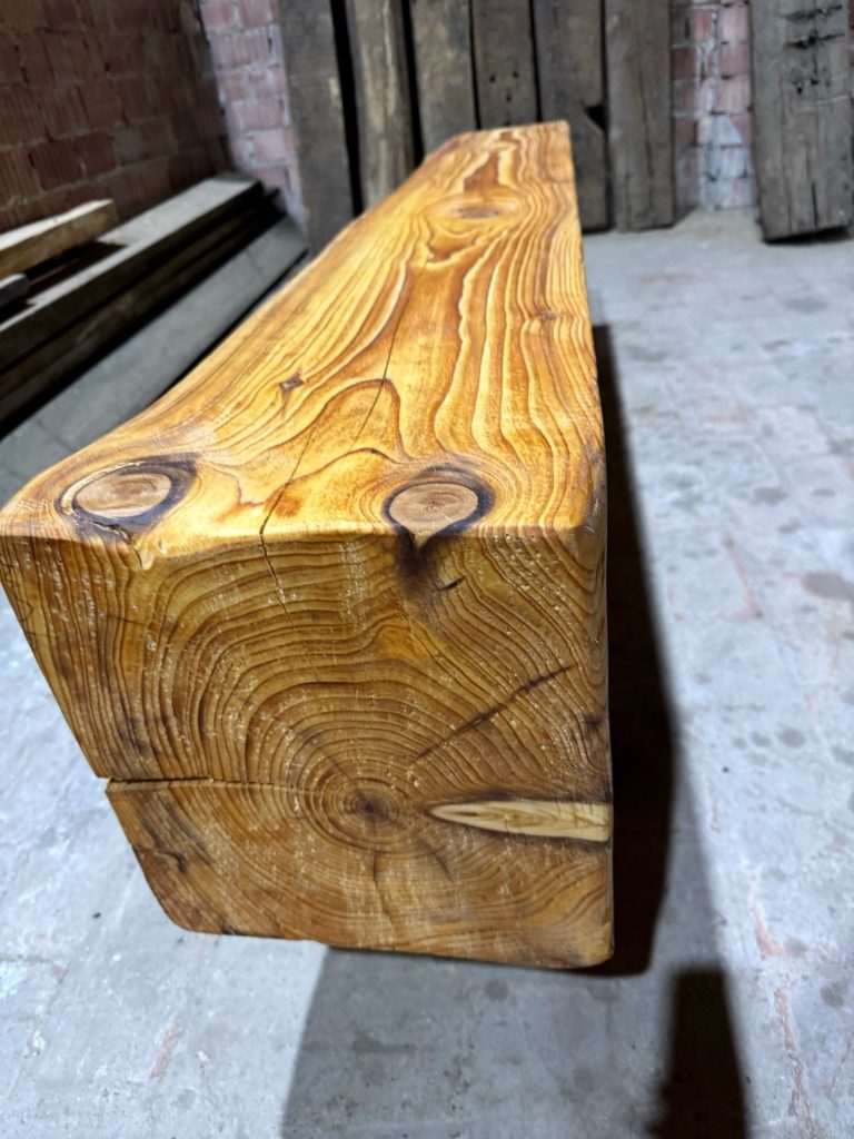 Massiver Balken mit Jahresringen und Rissen im Hirnholz