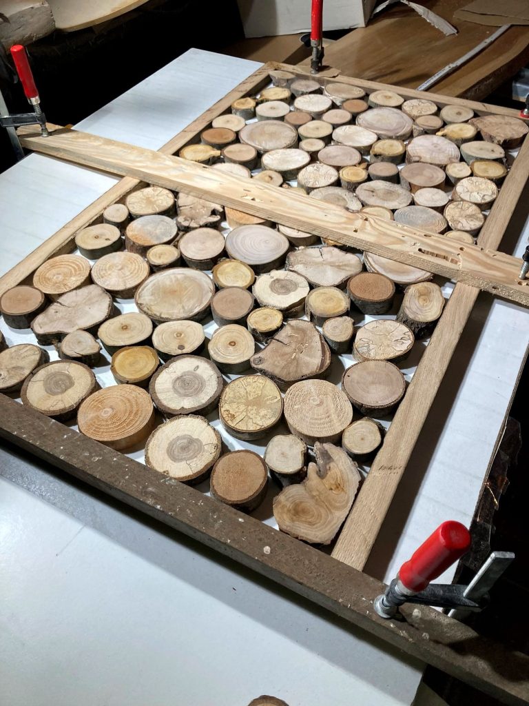 Wandbild aus vielen kleinen Baumscheiben in einem Holzrahmen